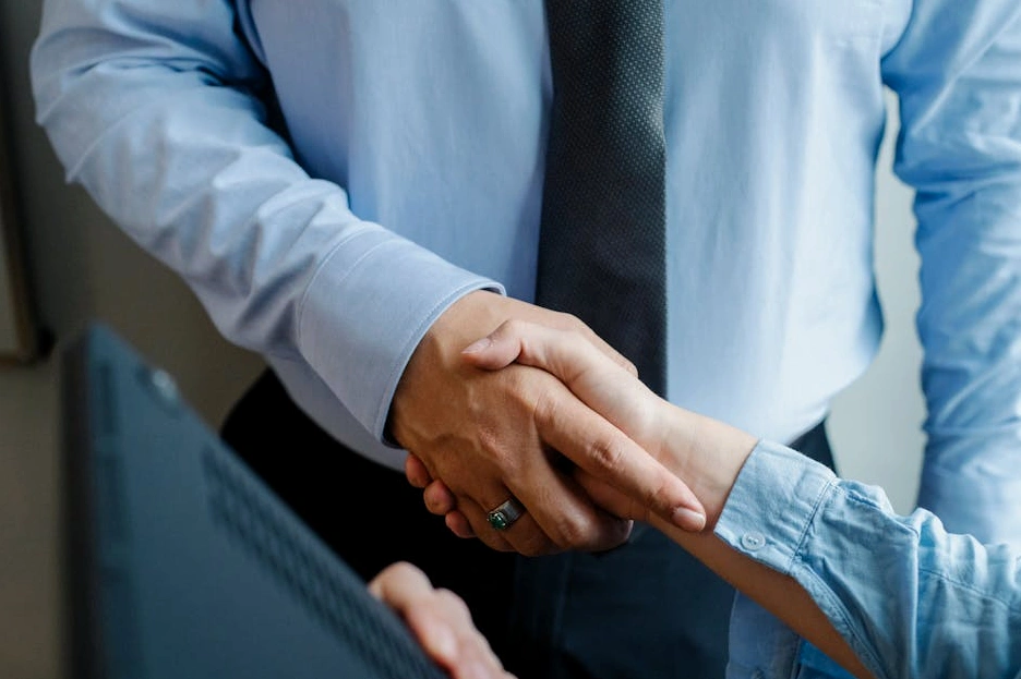 Uścisk dłoni dwóch biznesmenów na tle nowoczesnego biurowca